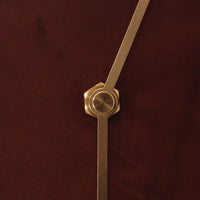 Gold hardware on a rich burgundy background with a smooth, textured finish. Elegant and modern design details.