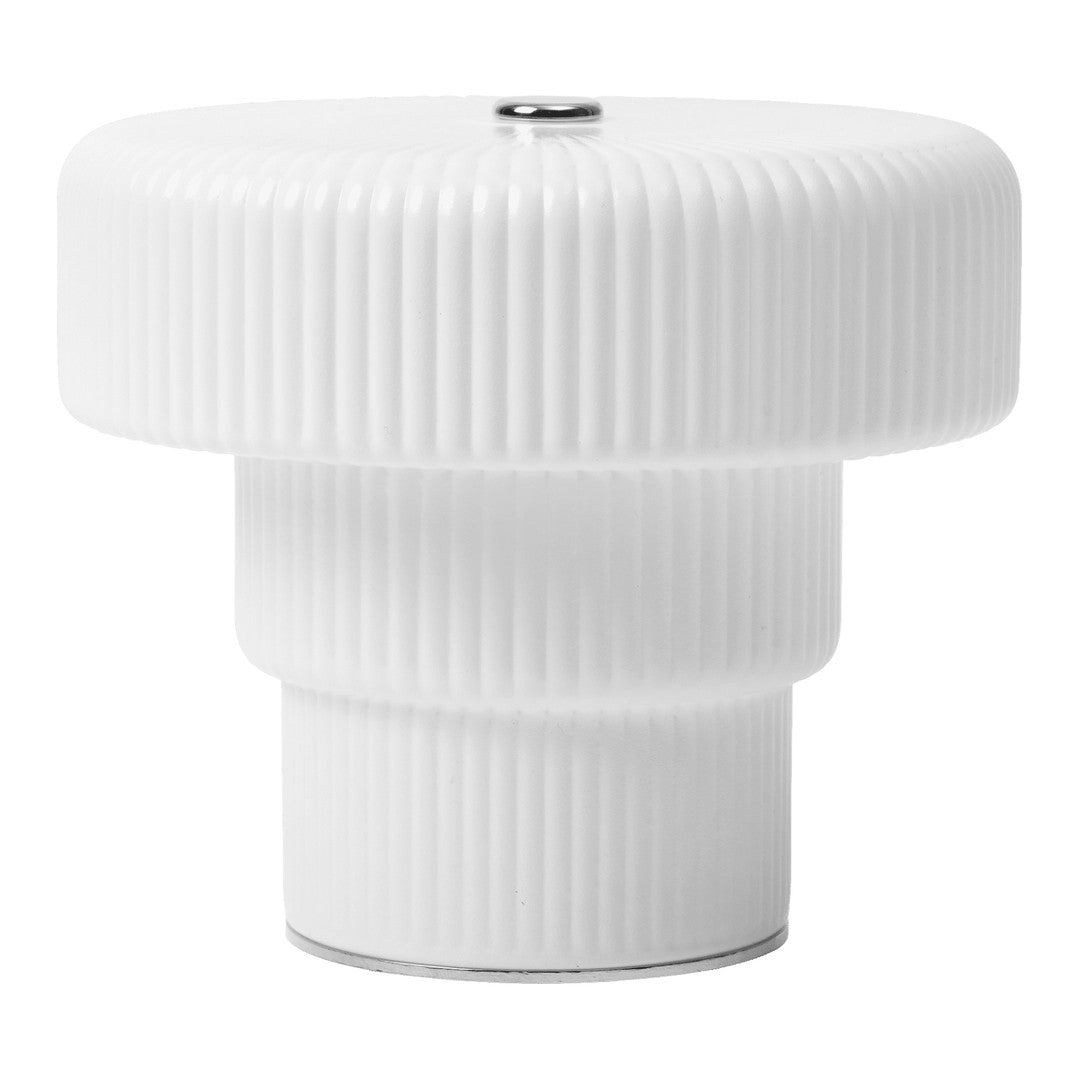White ribbed lamp base with a sleek, glossy finish and metallic accent on top for a modern aesthetic.