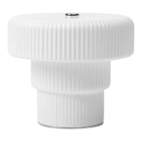 White ribbed lamp base with a sleek, glossy finish and metallic accent on top for a modern aesthetic.