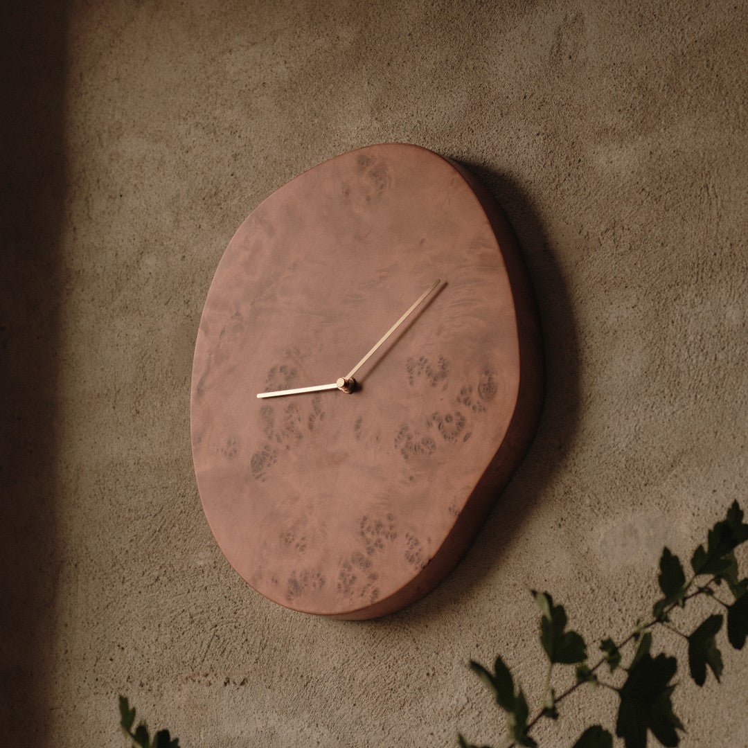 "Unique copper wall clock with natural wood patterns and a minimalist design, featuring gold-toned clock hands."