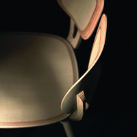 Light wood chair with smooth, natural grain and subtle contrasting curved accents in a dark background.