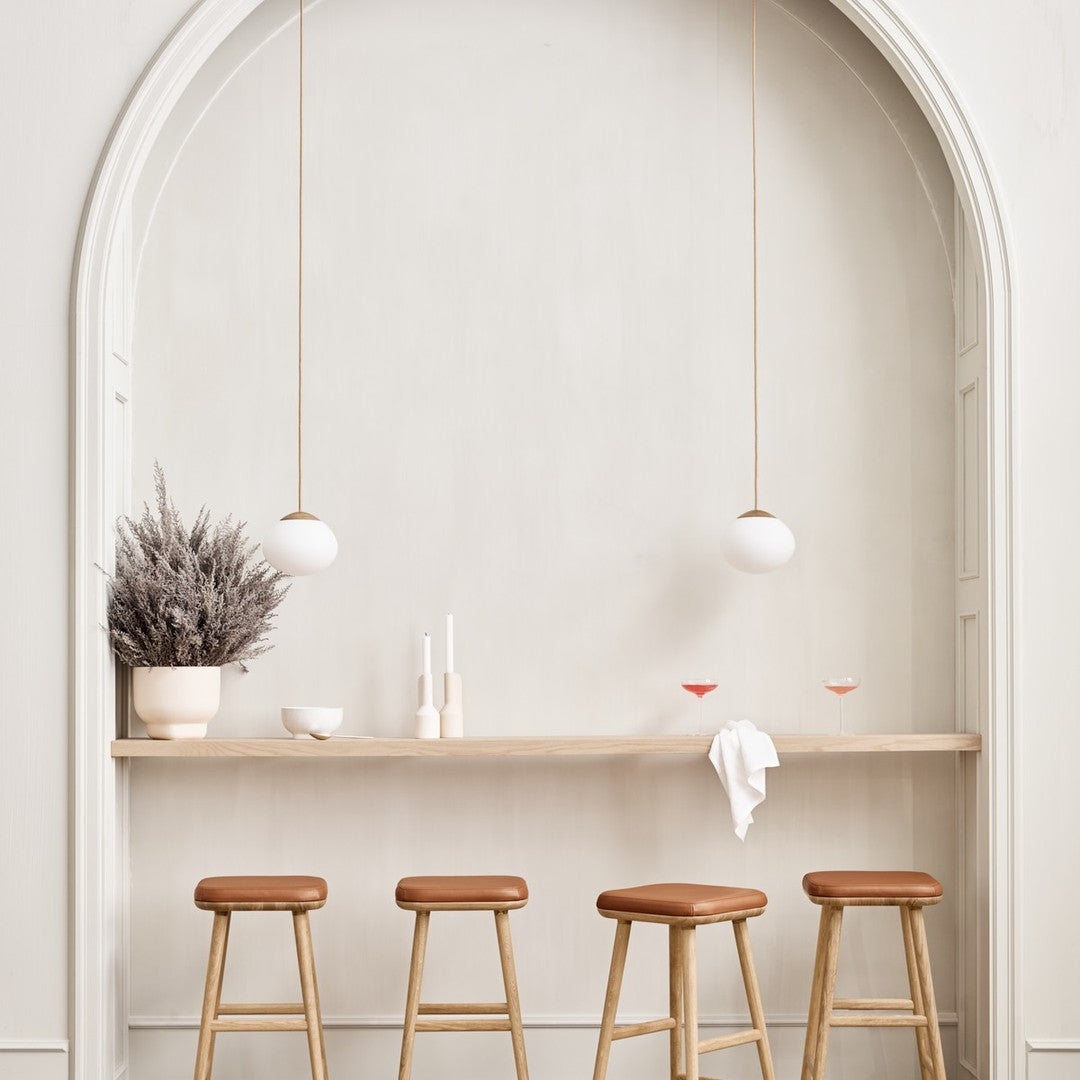 "Neutral tones with warm wooden accents and elegant white pendant lights, featuring soft textures and minimalist design."