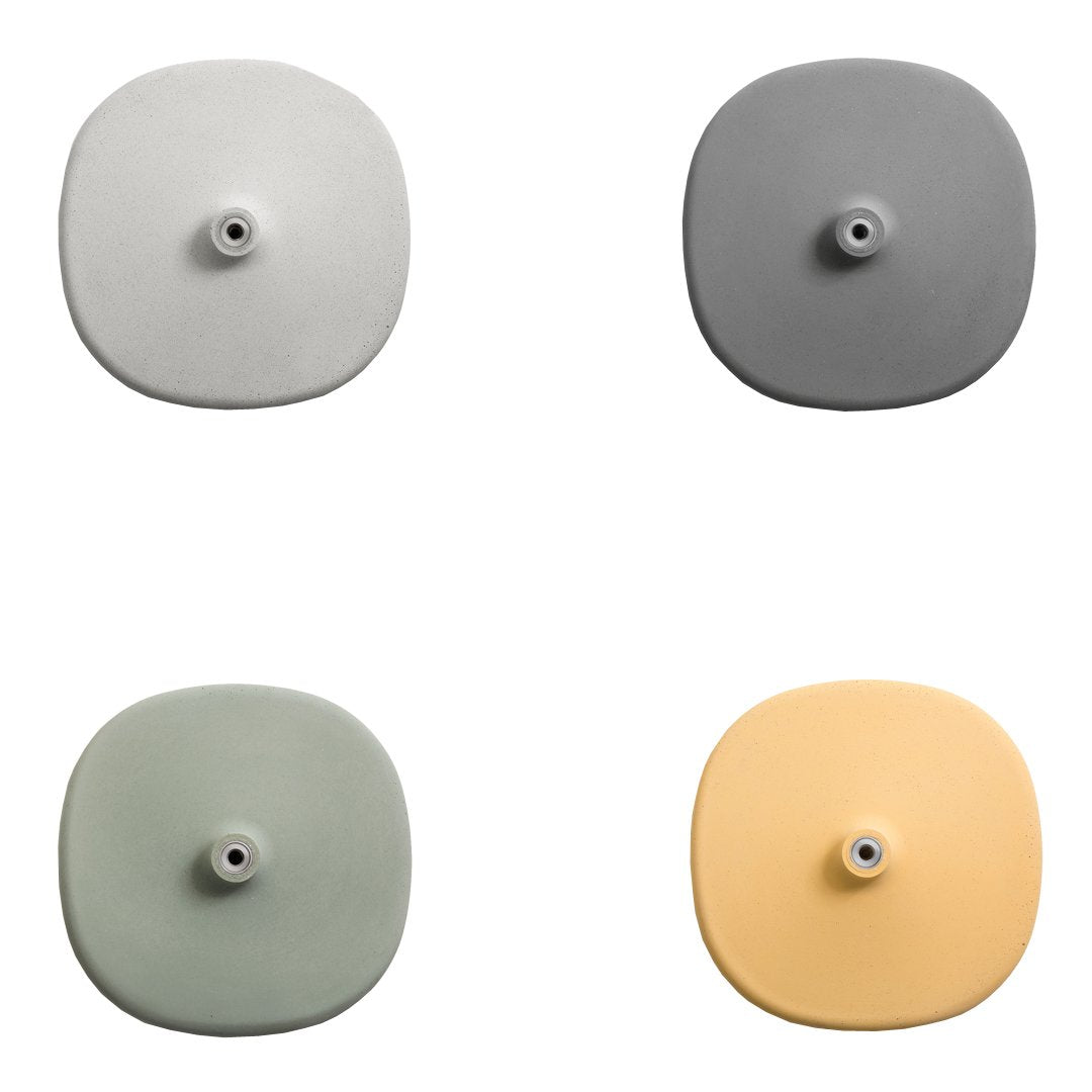 Four decorative wall hooks in light gray, dark gray, soft green, and pastel yellow, featuring smooth, round designs.