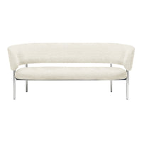 Cream curved sofa with plush upholstery and sleek chrome legs, featuring a minimalist design and soft textures.