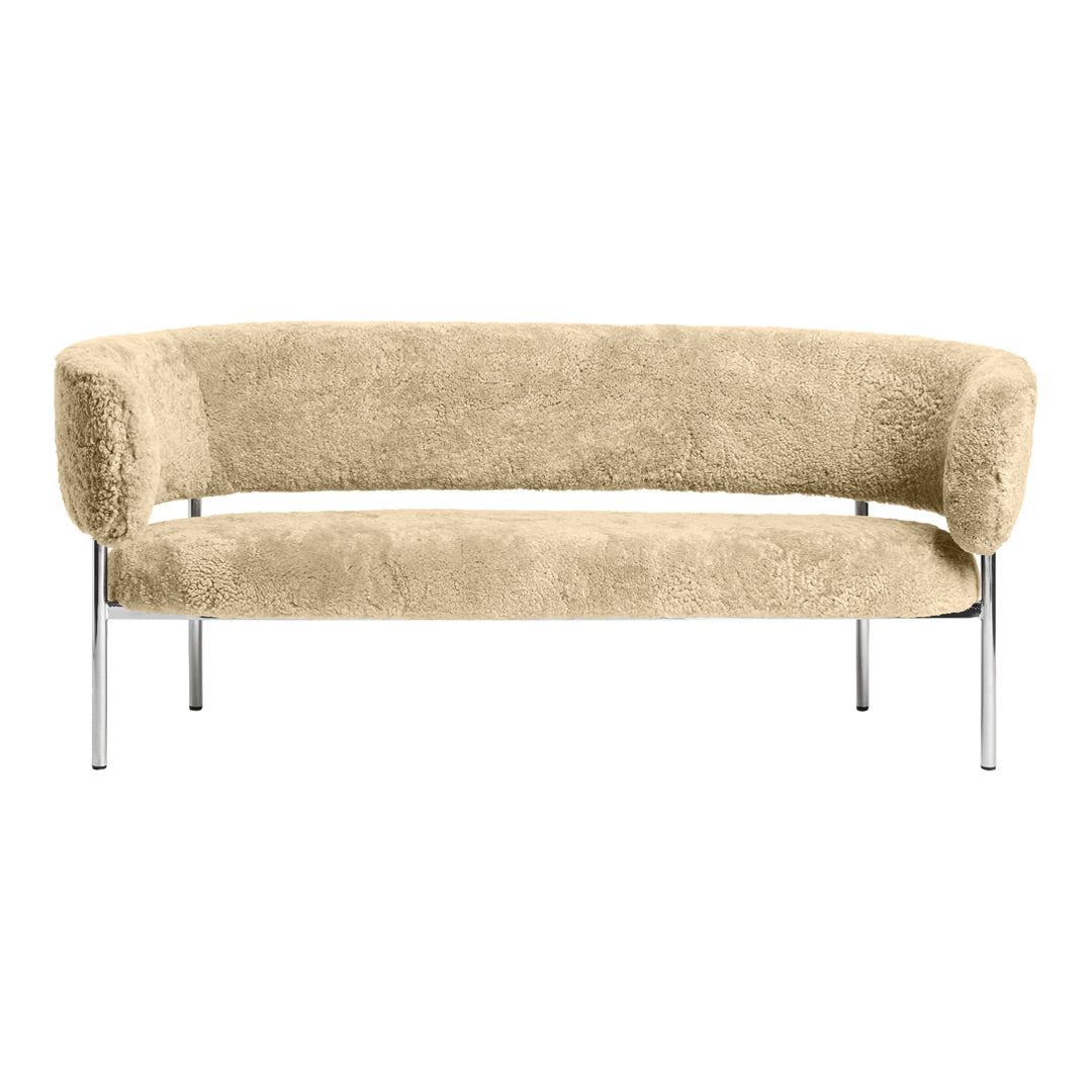 Beige plush curved sofa with chrome legs, showcasing a soft, textured surface. Ideal for modern decor.