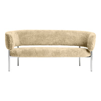 Beige plush curved sofa with chrome legs, showcasing a soft, textured surface. Ideal for modern decor.