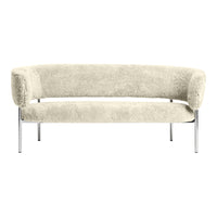 Cream-colored curved sofa with a soft, textured finish and sleek chrome legs. Elegant and modern design.