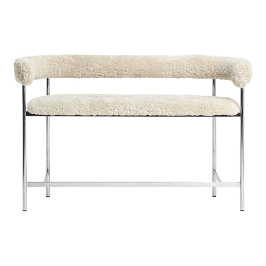 Cream sheepskin bench with chrome legs, featuring a sleek, modern design. Soft texture with minimalistic aesthetic.