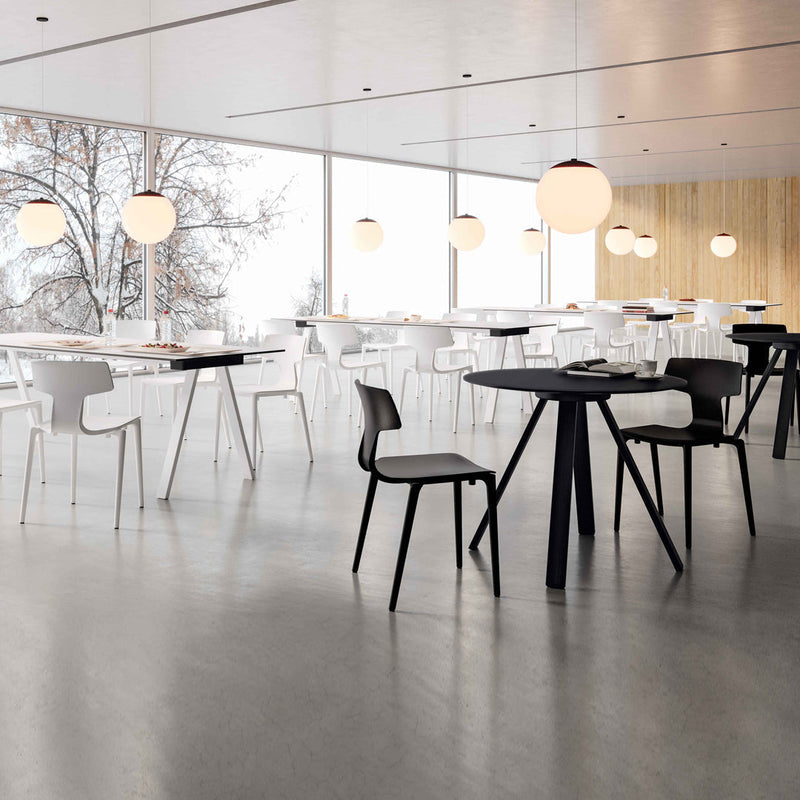 Modern dining space with white and black furniture, featuring sleek lines and minimalist design elements.