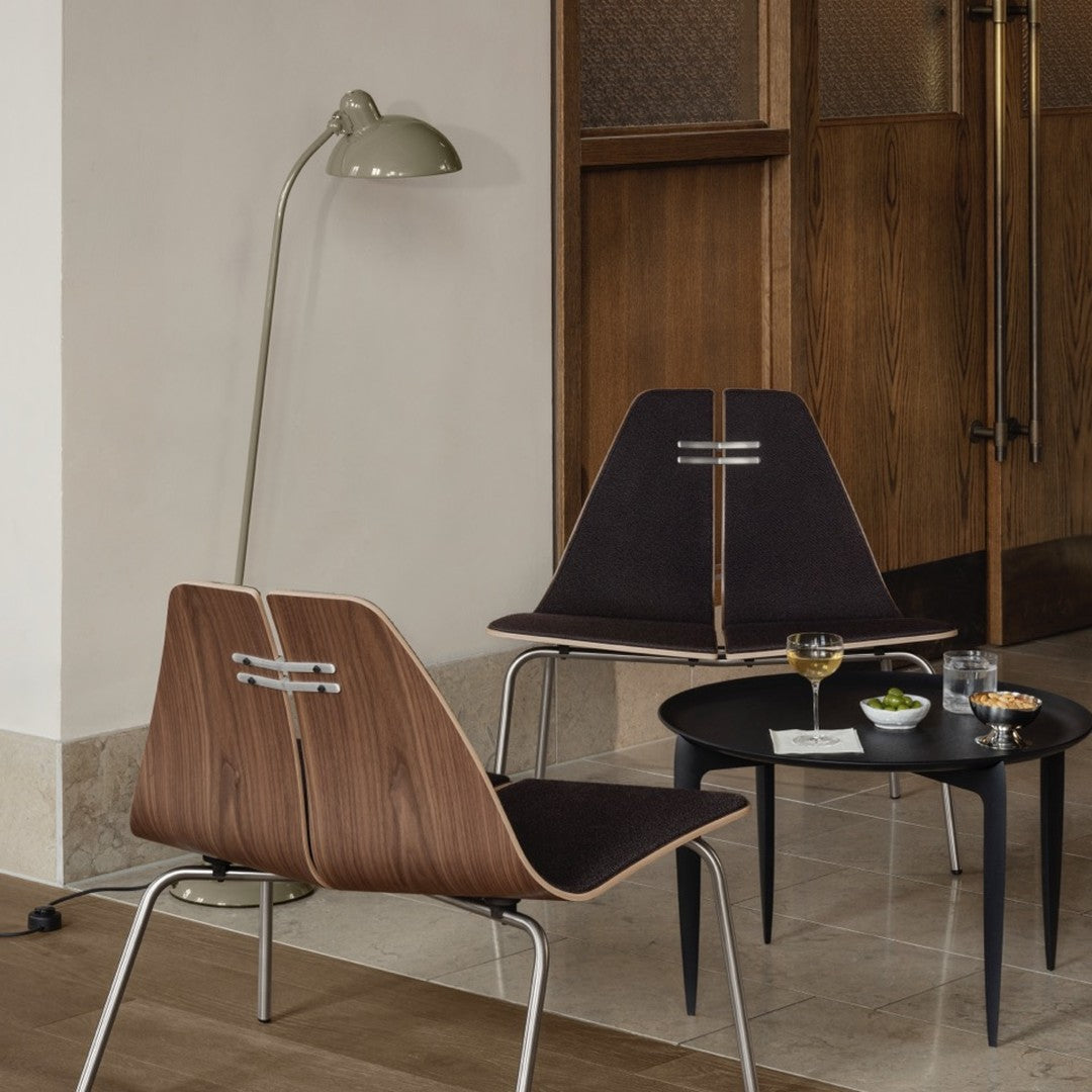 Mid-century modern chairs with walnut wood details, dark fabric upholstery, and a sleek black coffee table.