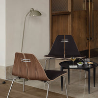 Mid-century modern chairs with walnut wood details, dark fabric upholstery, and a sleek black coffee table.
