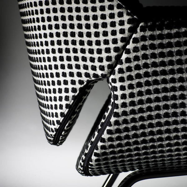 Black and white patterned chair close-up featuring a grid design and contrasting edge detailing.
