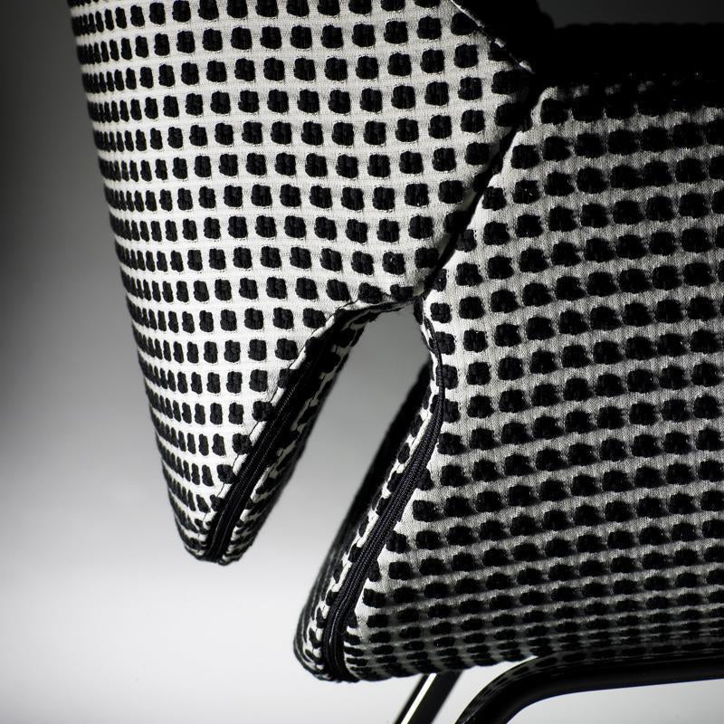 Black and white patterned chair close-up featuring a grid design and contrasting edge detailing.