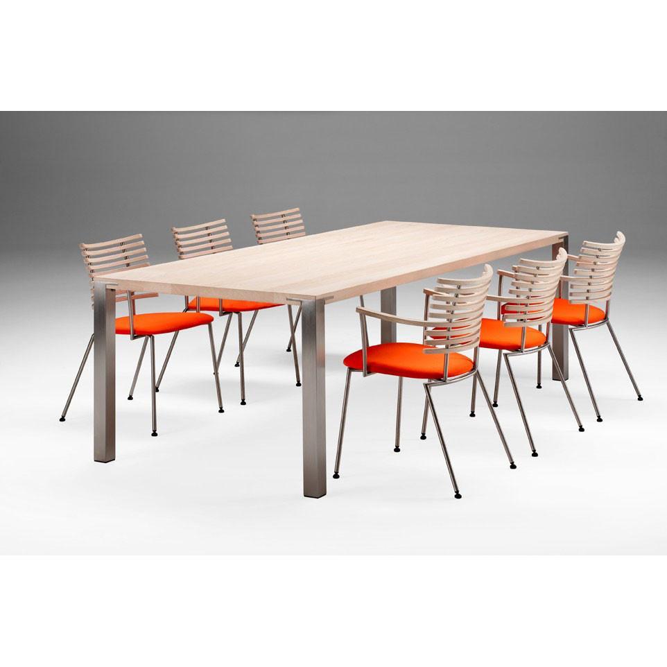 "Light wood table with metal legs and six modern chairs featuring orange cushions and silver backrests."