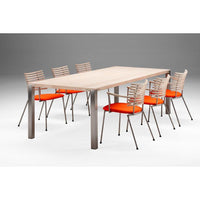 "Light wood table with metal legs and six modern chairs featuring orange cushions and silver backrests."