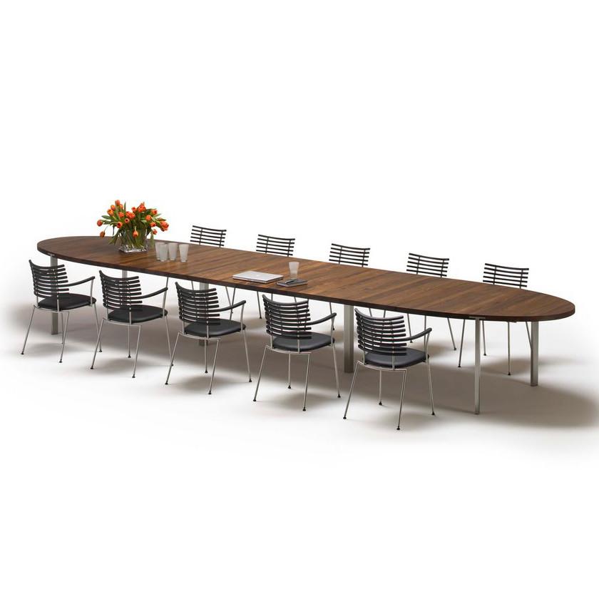 Long oval wooden dining table with a rich brown finish and sleek silver metal chairs, showcasing a modern aesthetic.