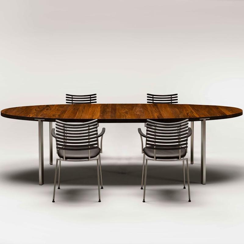 Wooden oval dining table with a rich brown finish and silver metal legs, complemented by sleek striped chairs.