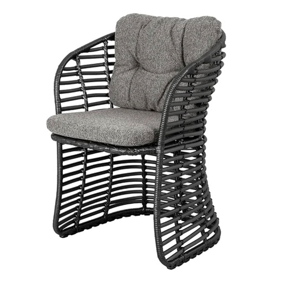 Stylish black wicker chair with a textured gray cushion, featuring a modern, open weave design.