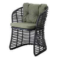 Green tufted cushion on a black woven chair showcasing a modern pattern and sleek design. Ideal for outdoor lounging.