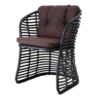 Brown upholstered cushion on a black woven frame chair with a unique curved design and open pattern.