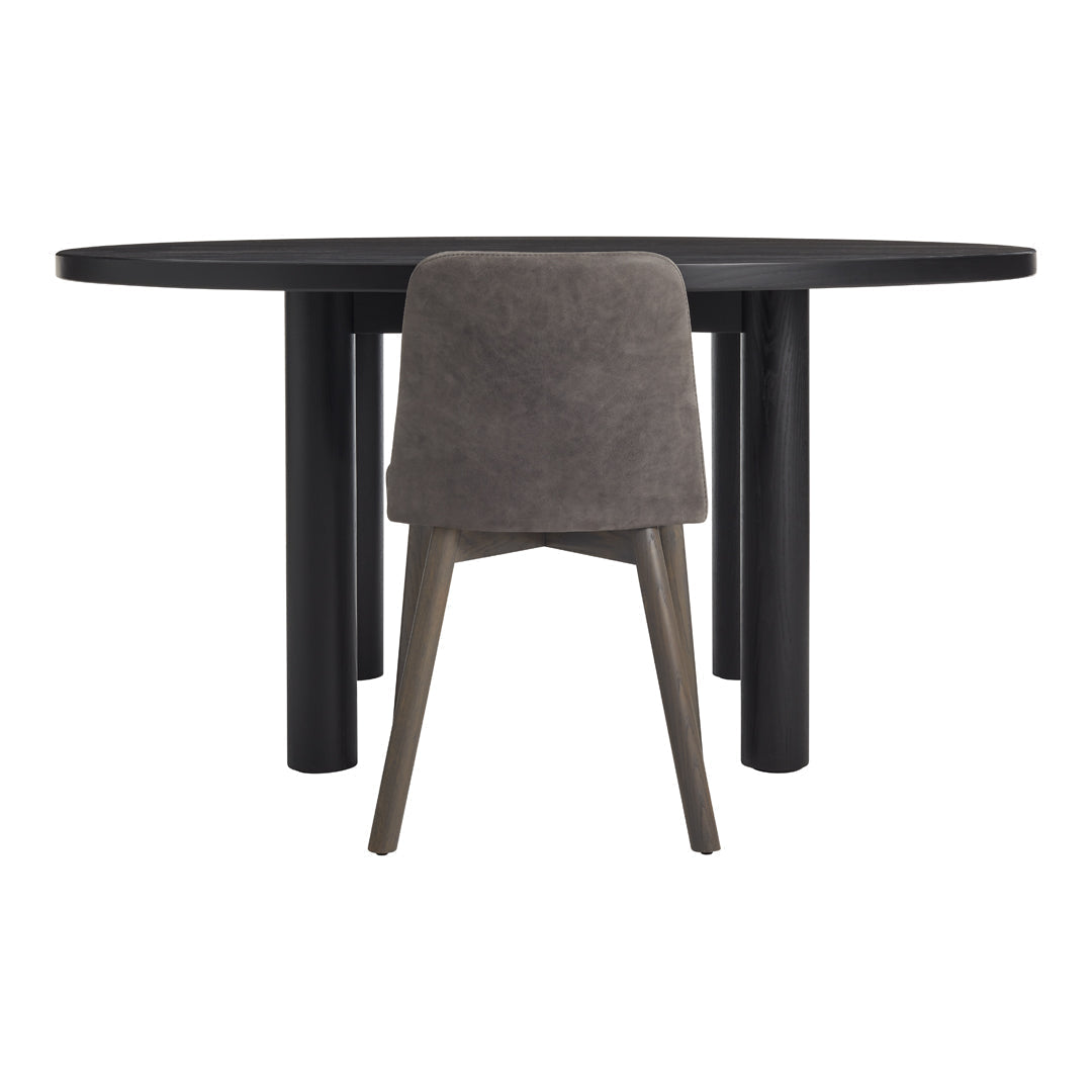 Round black dining table with a textured grey upholstered chair, showcasing a sleek, modern design.