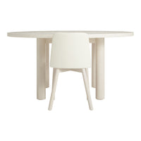 White round dining table with smooth, minimalist design and matching cream-colored chair. Modern, neutral aesthetic.