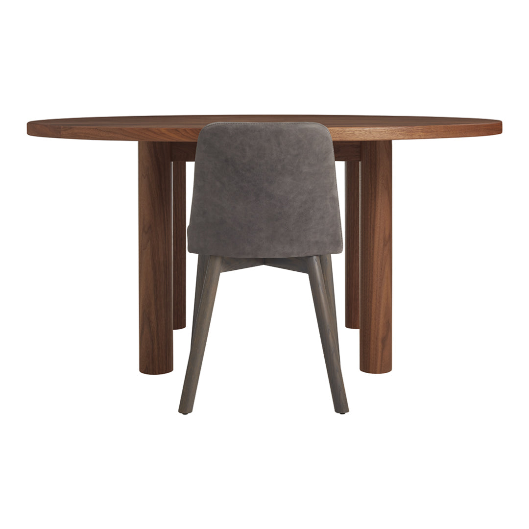 Round wooden dining table with a rich brown finish and a sleek grey upholstered chair. Modern and stylish design.