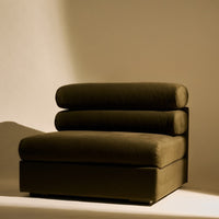 Olive green curved lounge chair with plush round cushions and a sleek rectangular base, perfect for modern decor.