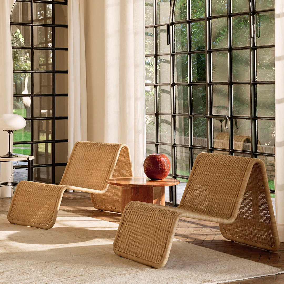 "Natural woven rattan lounges in a minimalist design, featuring warm beige tones and smooth curves."