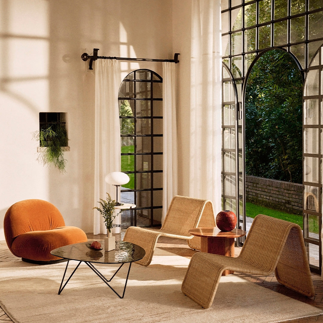 Modern seating in warm orange and natural tones, featuring organic shapes and textures against a bright, airy backdrop.