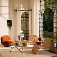 Modern seating in warm orange and natural tones, featuring organic shapes and textures against a bright, airy backdrop.