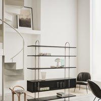 Elegant black metal shelving unit with clear and frosted glass accents in a minimalist, neutral-toned setting.