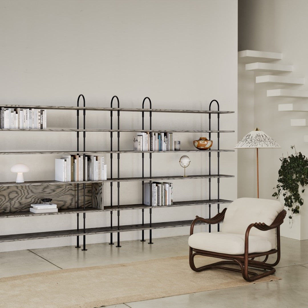 Modern shelving unit with black metal frame, neutral wooden shelves, and beige upholstery accents. Elegant minimalist design.