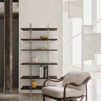 Modern black wood shelf with silver metal accents, featuring minimalist decor and a white backdrop. Gold decorative pieces.