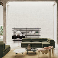 "Modern living room with olive green sofas, black metal shelves, and beige accents, featuring a minimalist, neutral backdrop."