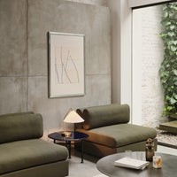 "Modern olive green sofas with minimalistic patterns, paired with a round black table and warm accent lighting."