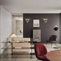 Modern living room featuring neutral tones, black accents, and a deep burgundy chair with sleek lines and soft textures.