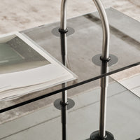Elegant glass coffee table with sleek silver metal accents and black circular glass supports, featuring a minimalist design.