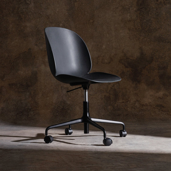 Black ergonomic office chair with a smooth, minimalist design, featuring a solid color and sleek, modern lines.