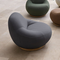 Curved gray chair with smooth fabric and wooden base, featuring a minimalist and modern design. Ideal for stylish interiors.
