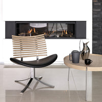 Modern chair with wood slats and black leather seat, paired with a round coffee table in neutral tones. Stylish and minimalistic.