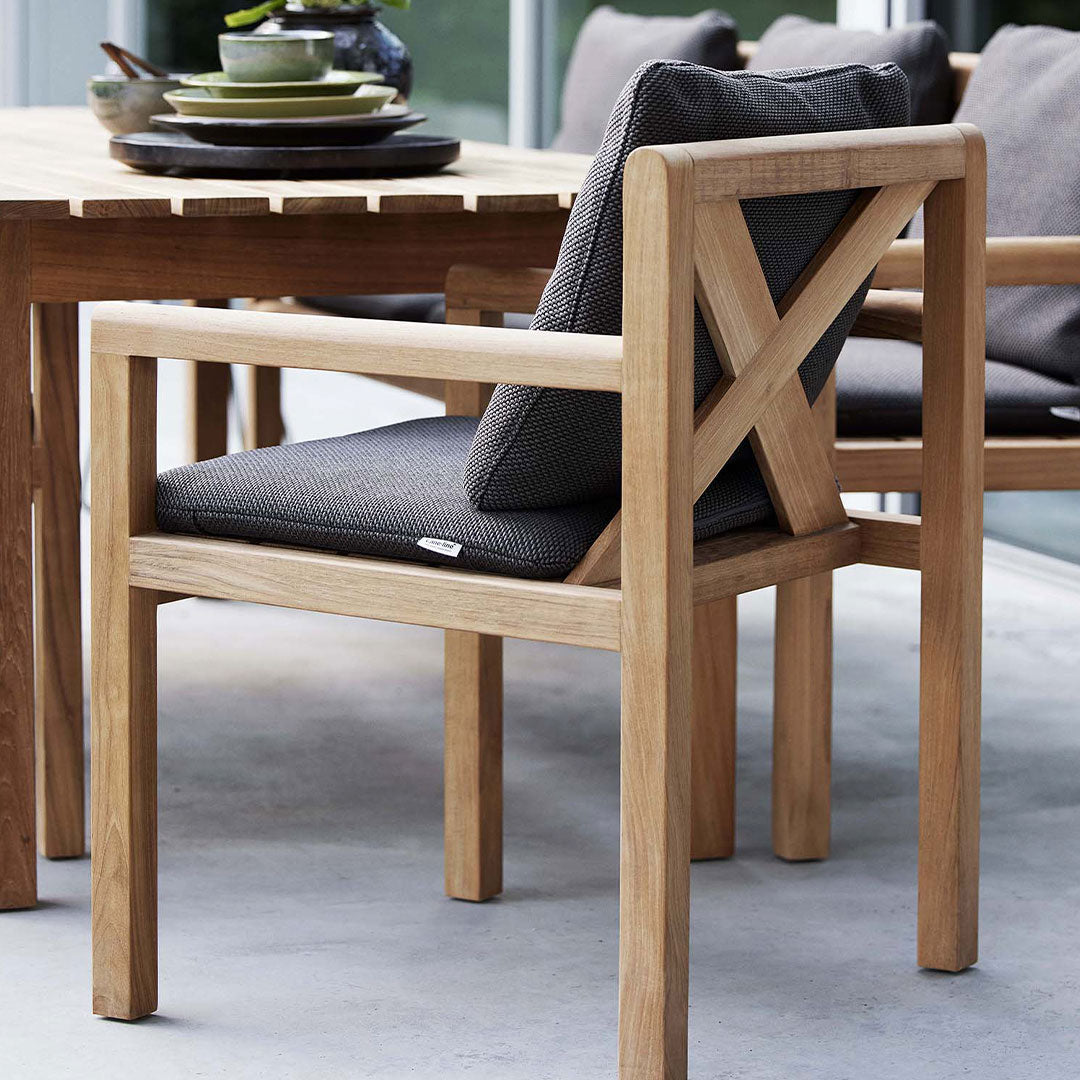 Light wood chair with a textured dark gray cushion, featuring a minimalist design and subtle patterns.