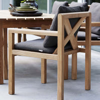 Light wood chair with a textured dark gray cushion, featuring a minimalist design and subtle patterns.