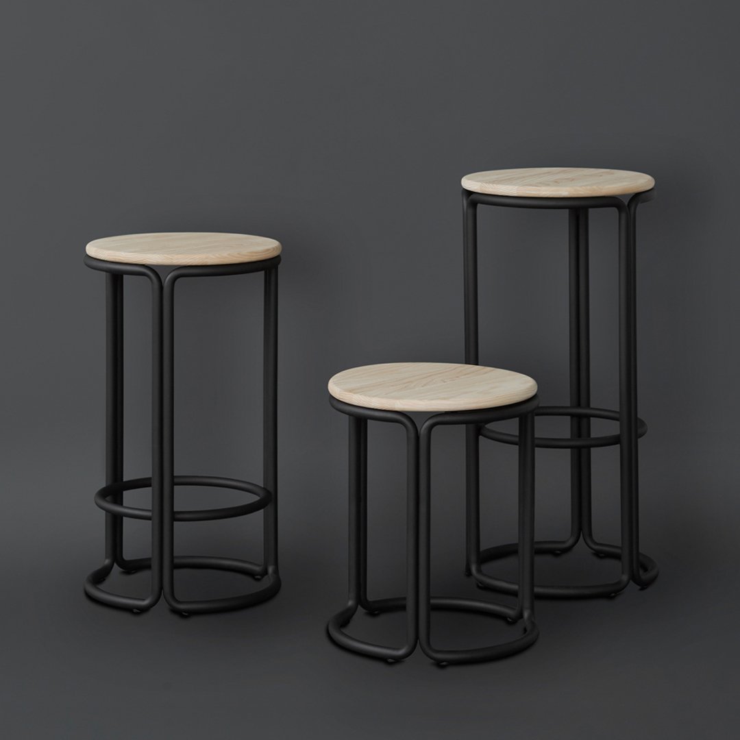Three modern bar stools featuring round wood tops and sleek black metal frames, set against a dark backdrop.