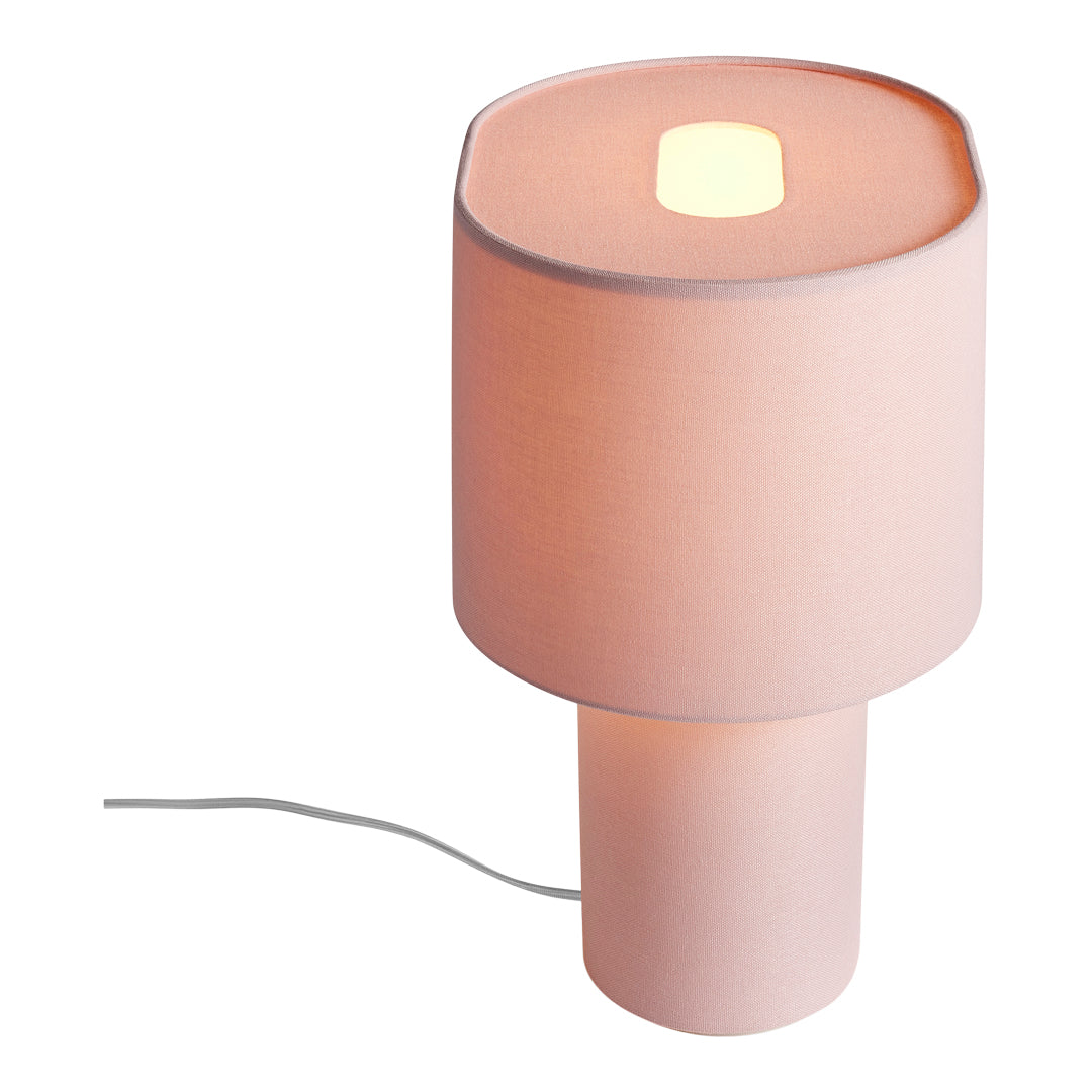 Soft pink lamp with a smooth fabric shade and cylindrical base, featuring a simple, modern design.