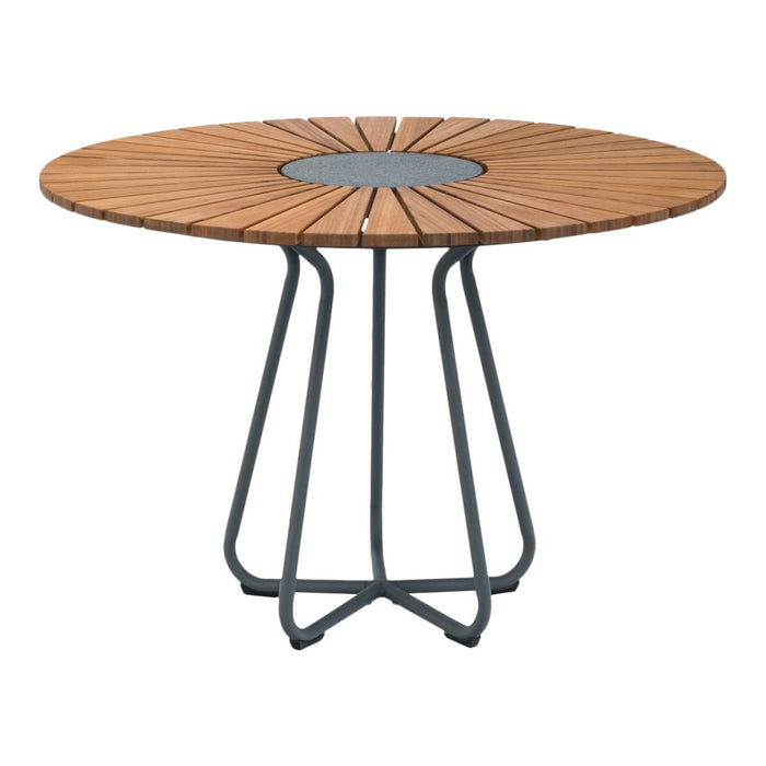 Round wood dining table with a natural wooden slat pattern and a dark metal base, perfect for modern outdoor spaces.