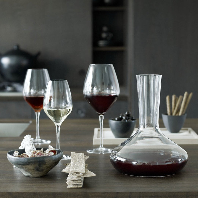 Elegant glassware setup featuring clear and colored glasses, a sleek carafe, and minimalistic black and white decor.
