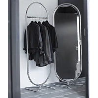 "Elegant chrome clothing rack with black garments against a sleek monochrome background."