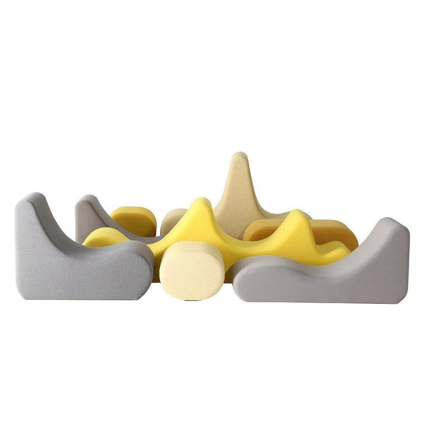 Colorful abstract foam seating in shades of yellow, grey, and beige with smooth, wavy contours and playful shapes.