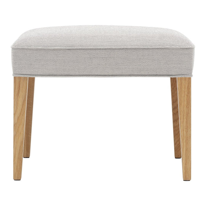 Light gray upholstered stool with natural wood legs, featuring a smooth, minimalist design. Ideal for modern decor.